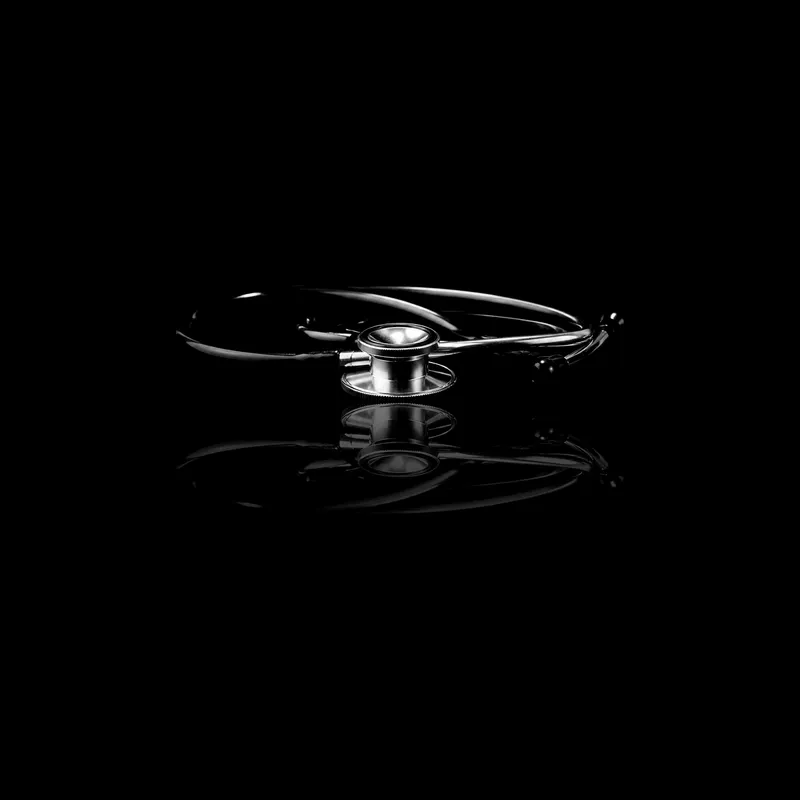 Stéthoscope enroulé, posé sur un miroir noir qui le reflète